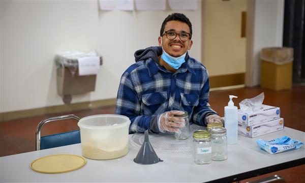 Boy smiles while filling jar with sugar